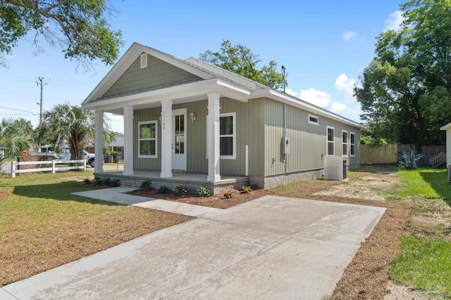 view of front of house with a porch, fence, and a front lawn