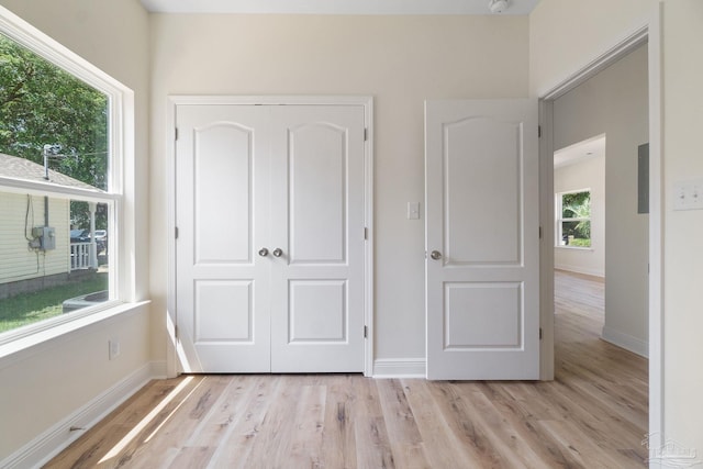 unfurnished bedroom featuring light wood-type flooring, a closet, and baseboards