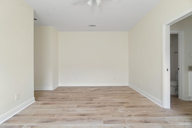 spare room with baseboards, visible vents, and light wood-style floors