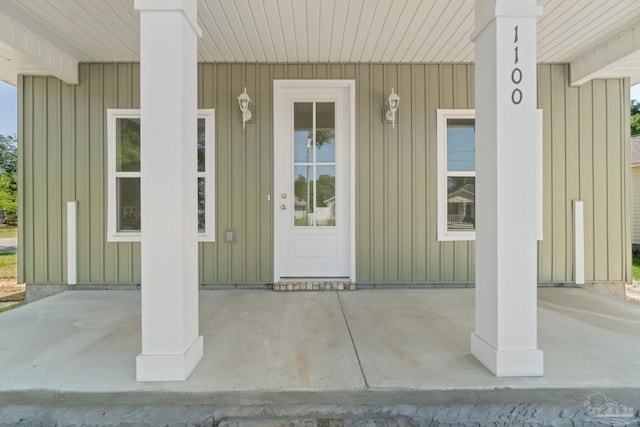 doorway to property featuring covered porch and board and batten siding