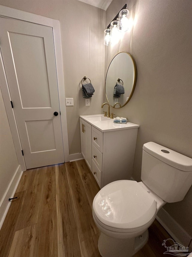 bathroom with vanity, toilet, and hardwood / wood-style floors