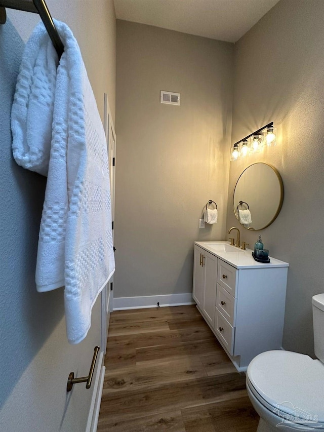 bathroom featuring hardwood / wood-style flooring, vanity, and toilet