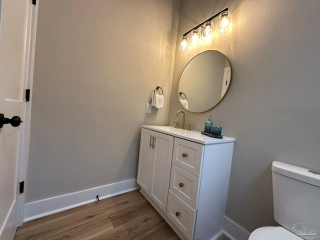 bathroom with vanity, hardwood / wood-style floors, and toilet