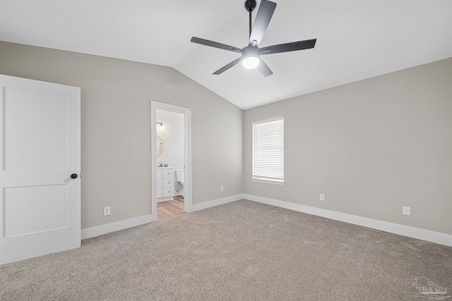 unfurnished bedroom with light carpet, lofted ceiling, ceiling fan, and ensuite bathroom