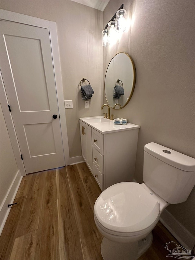 bathroom with wood-type flooring, toilet, and vanity