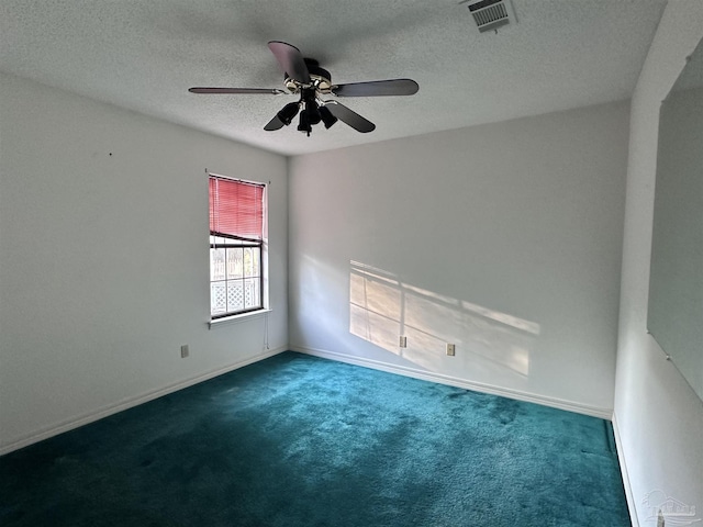 carpeted spare room featuring a ceiling fan, visible vents, a textured ceiling, and baseboards