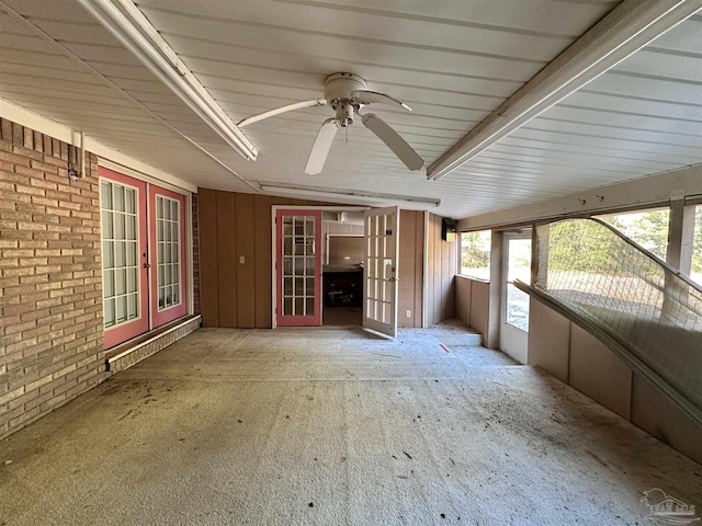 unfurnished sunroom featuring ceiling fan and french doors