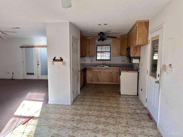 kitchen with ceiling fan, stove, a sink, and visible vents