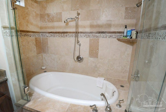 full bathroom with a garden tub and a tile shower