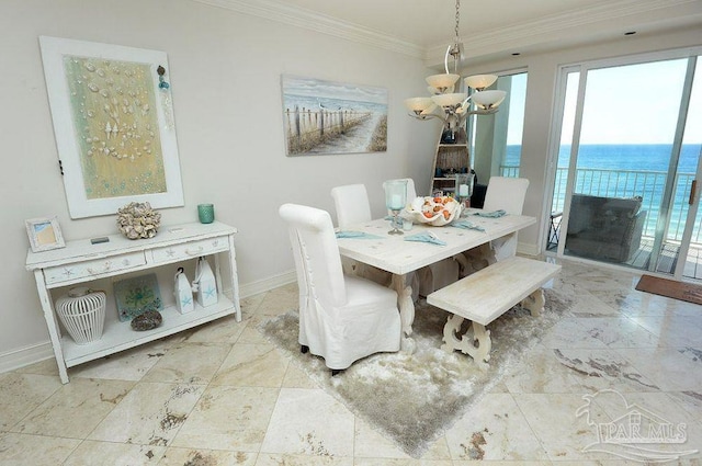 dining room featuring ornamental molding, baseboards, a chandelier, and a water view