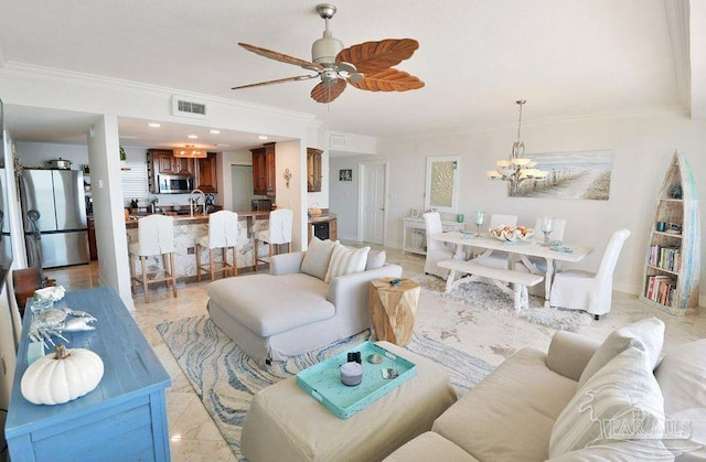 living room with ornamental molding, a chandelier, and ceiling fan