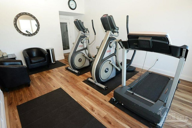 workout room featuring wood finished floors and baseboards