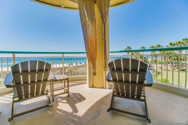 view of patio / terrace featuring a view of the beach, a water view, and a balcony