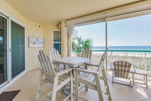 view of patio with a beach view, a balcony, and a water view