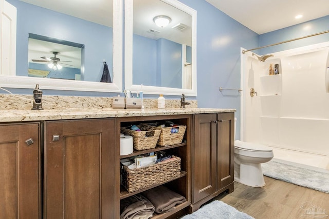 bathroom featuring toilet, vanity, a shower, ceiling fan, and hardwood / wood-style flooring