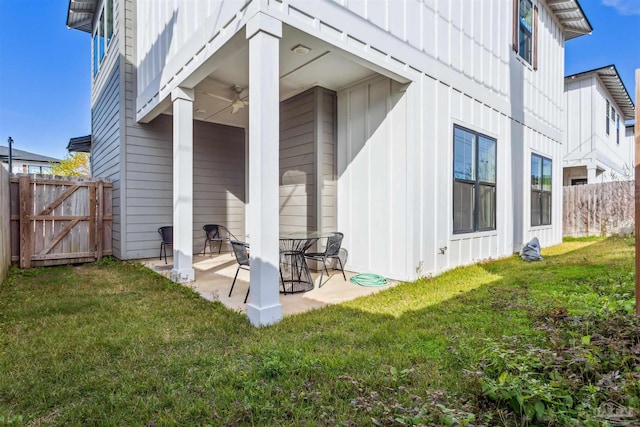 back of property featuring a lawn, ceiling fan, and a patio