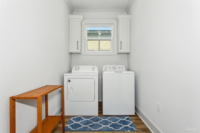 laundry room with cabinets, dark wood-type flooring, and washing machine and clothes dryer