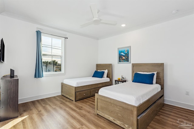 bedroom with ceiling fan, wood-type flooring, and ornamental molding