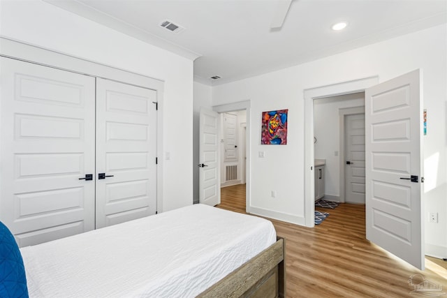 bedroom featuring ceiling fan, a closet, and hardwood / wood-style flooring