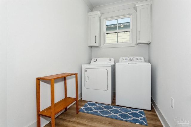 washroom featuring cabinets, separate washer and dryer, and dark wood-type flooring