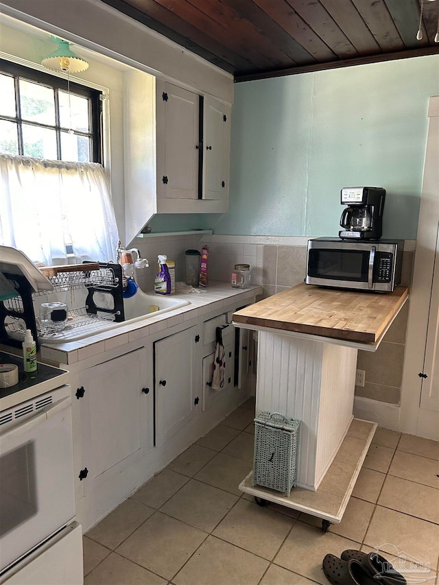 kitchen featuring white cabinets, white electric range oven, light tile patterned flooring, wooden ceiling, and decorative backsplash