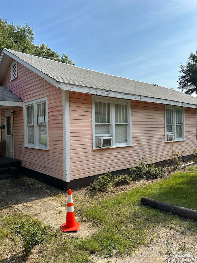 view of side of property featuring a lawn and cooling unit