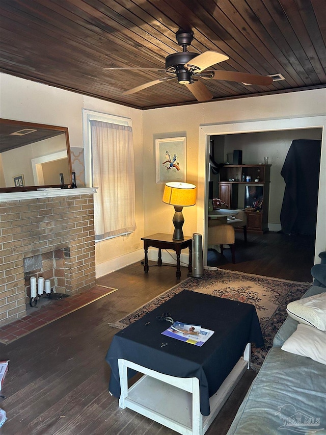 living room with wooden ceiling, dark wood-type flooring, ceiling fan, and a brick fireplace