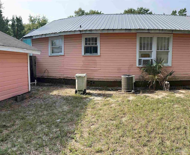 back of house with a lawn and central AC unit