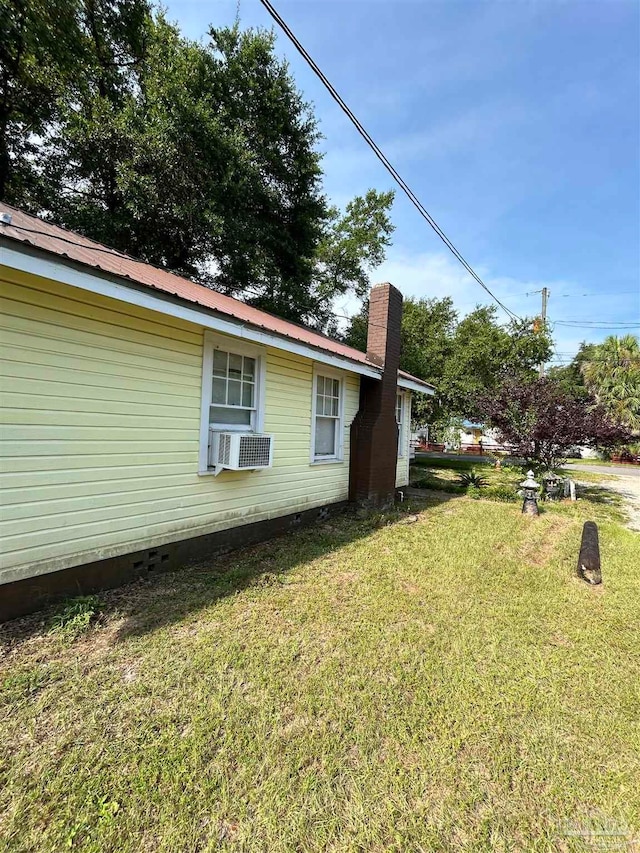 view of side of property featuring cooling unit and a yard