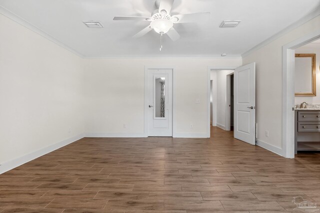 103 Florida Ave, Gulf Breeze, FL 32561 - unfurnished bedroom with wood finished floors, visible vents, crown molding, and baseboards
