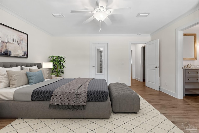 bedroom featuring crown molding, connected bathroom, light wood-type flooring, and ceiling fan