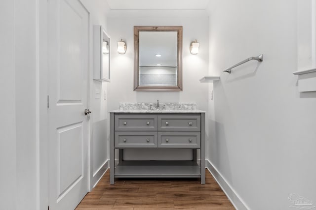 bathroom with wood-type flooring, vanity, and crown molding