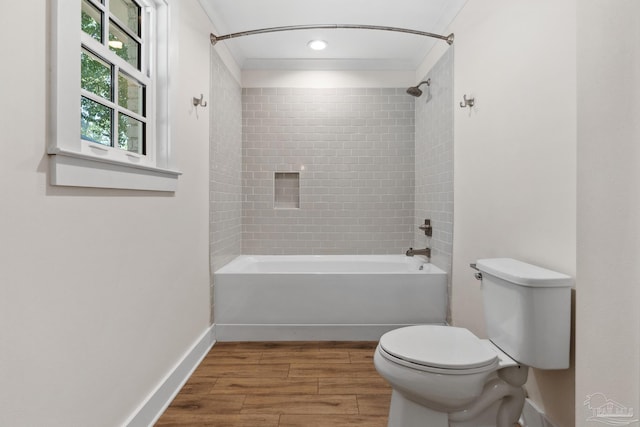 bathroom with tiled shower / bath, ornamental molding, toilet, and wood-type flooring