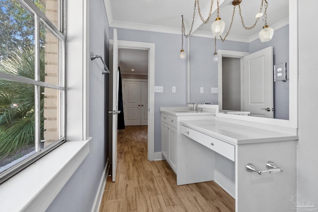 bathroom with crown molding, a chandelier, vanity, and wood-type flooring