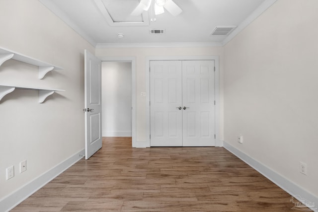 unfurnished bedroom with a closet, ornamental molding, light wood-type flooring, and ceiling fan