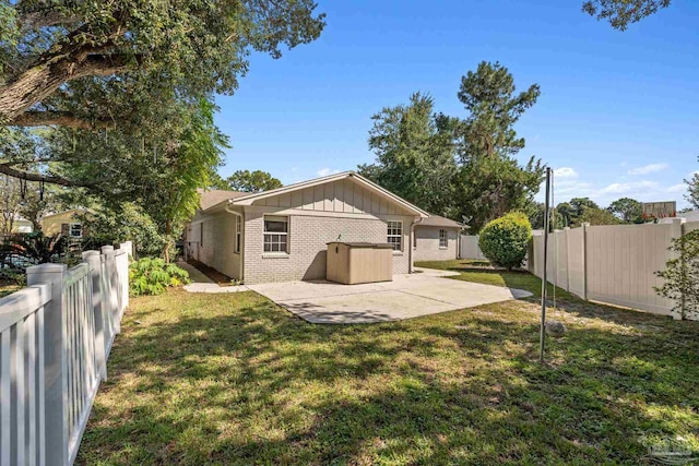 rear view of house featuring a yard and a patio area