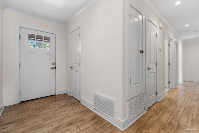 foyer entrance with crown molding and light wood-type flooring