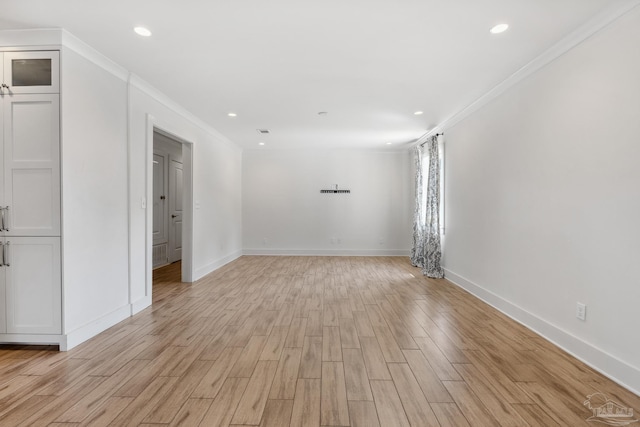 spare room featuring light hardwood / wood-style floors and crown molding