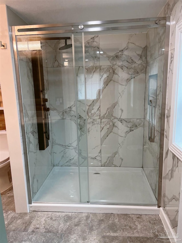 bathroom featuring tile patterned floors, toilet, and an enclosed shower