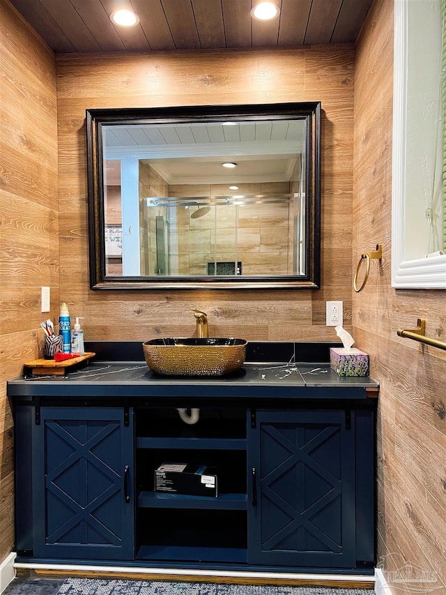 interior space with wooden ceiling, wooden walls, an enclosed shower, and vanity