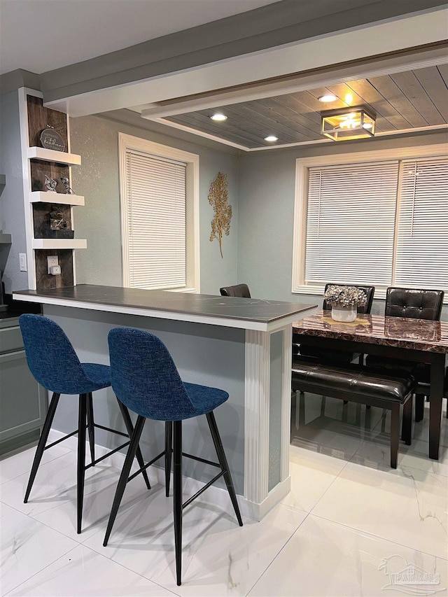 kitchen with wooden ceiling and light tile patterned floors