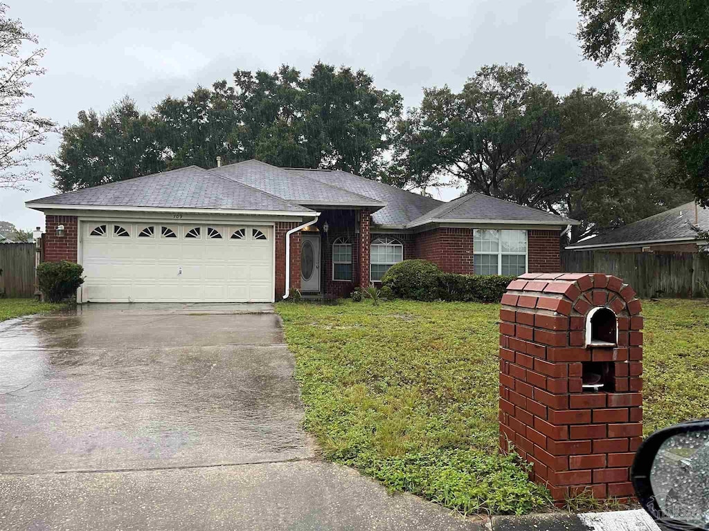 ranch-style house featuring a garage and a front lawn