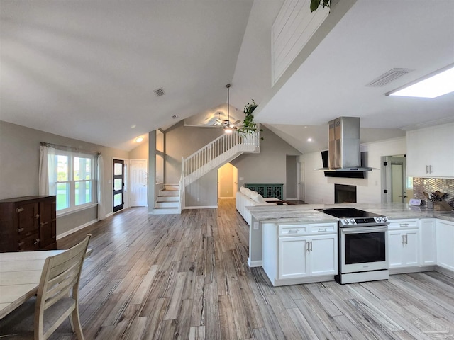 kitchen featuring ventilation hood, range with electric stovetop, white cabinetry, and light hardwood / wood-style flooring