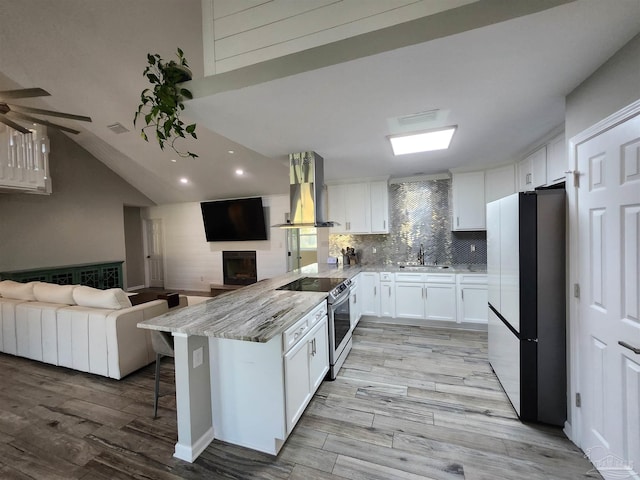 kitchen with a breakfast bar area, appliances with stainless steel finishes, white cabinetry, kitchen peninsula, and island exhaust hood