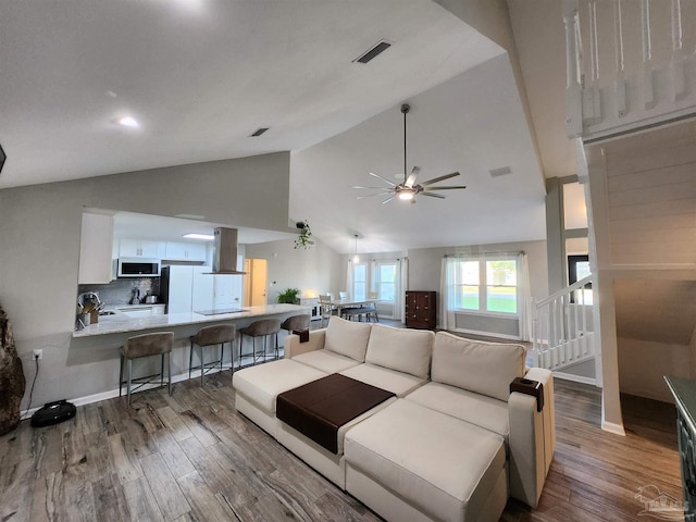 living room featuring hardwood / wood-style flooring, ceiling fan, and high vaulted ceiling