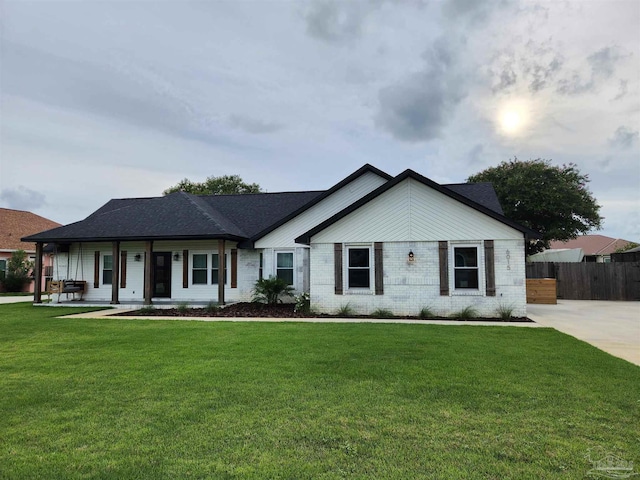 ranch-style house featuring a porch and a front lawn