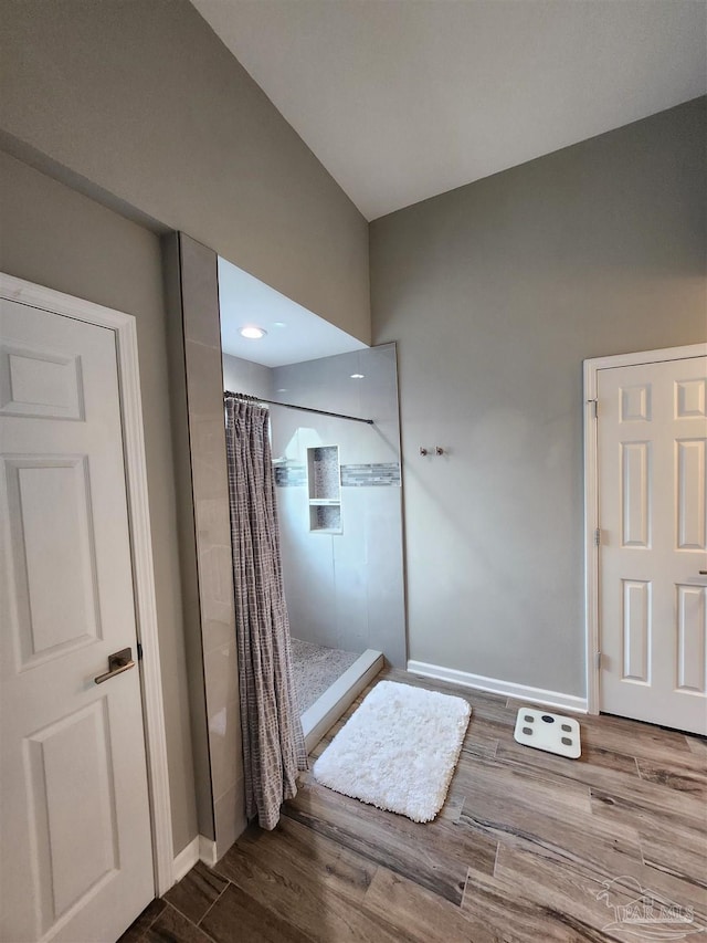 bathroom with a shower with shower curtain and wood-type flooring