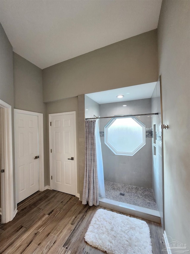 bathroom with a shower with curtain and hardwood / wood-style floors