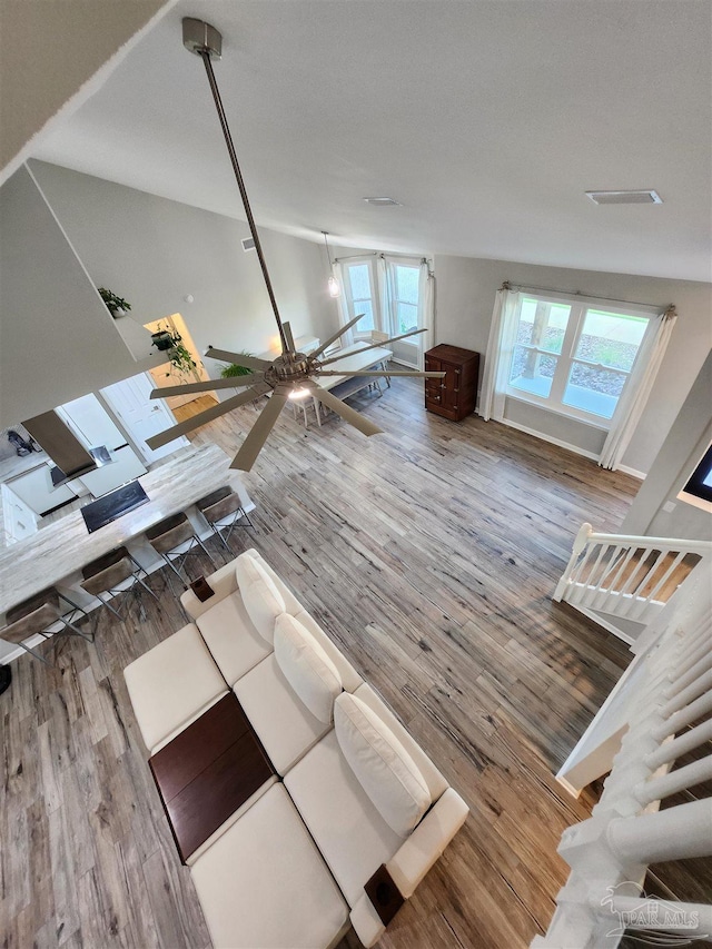 unfurnished living room featuring wood-type flooring, plenty of natural light, and ceiling fan