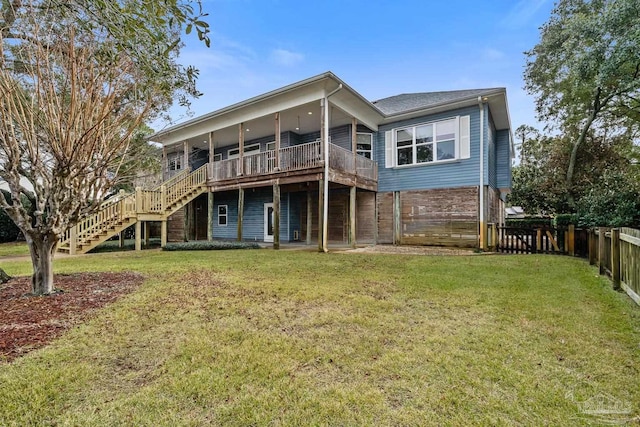 rear view of house with a lawn and a wooden deck